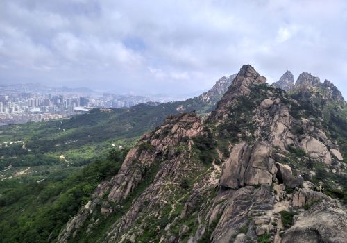 A mountain range with a large city in the background.
