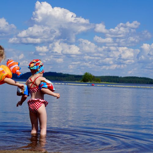 Two young girls playing in a lake.
