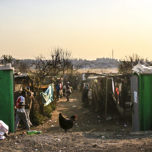 Looking down a road through a shanty town in South Africa.