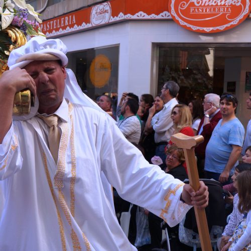 A man struggles to carry a heavy religious float during an Easter parade