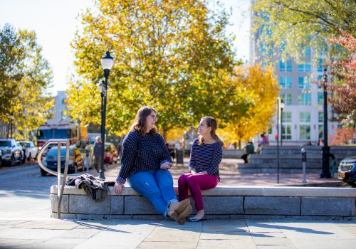 Two students talking and sitting in downtown asheville